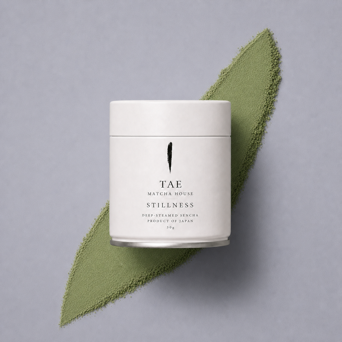TAE Matcha House Stillness — 30g tin on a smear of matcha powder